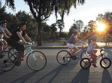A family cycling at dusk in Vancouver, Canada.